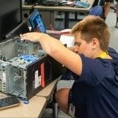 A youth works on a computer in a cybersecurity outreach class