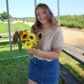 Image of Michigan Tech Pre-Physical Therapy student Emma DeBaeke holding bouquet of sunflowers
