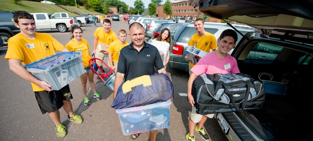 Families help carry items from their cars to their students' residence hall