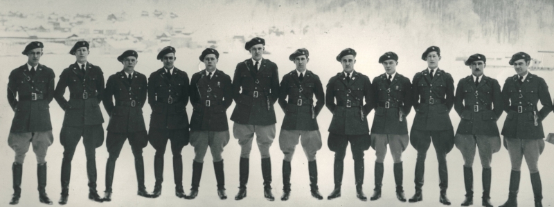 Early 1900s group photo of twelve officers of Engineer Unit of the Reserve Officers Training Corps at the Michigan College of Mining and Technology, the former name of Michigan Tech, standing in a line at attention on the ice of the Keweenaw Waterway in front of Mont Ripley.
