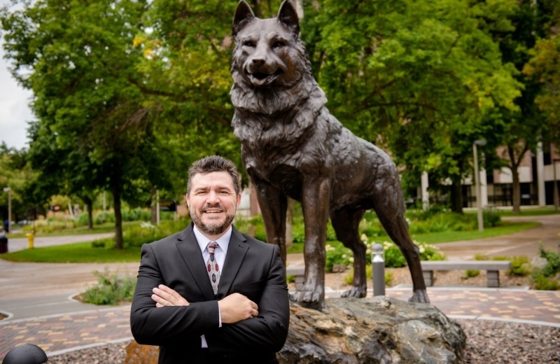 Dean Johnson in front of the Husky statue.