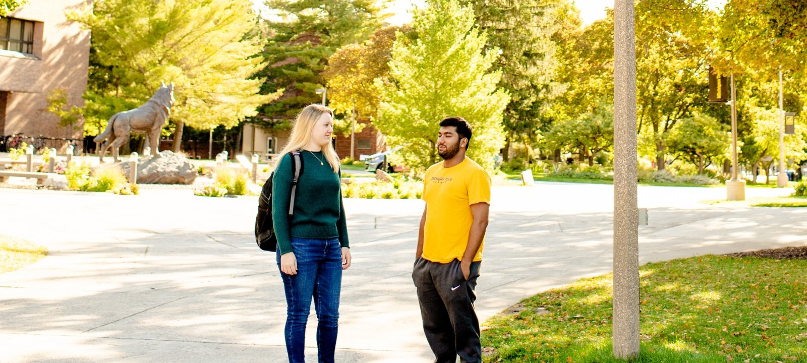 College of Business students talking in front of the campus library entrance