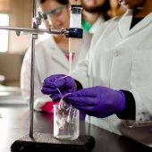 Students in a chemistry lab measuring a liquid in a beaker