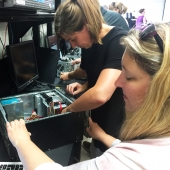 Teacher working with a student building a computer.