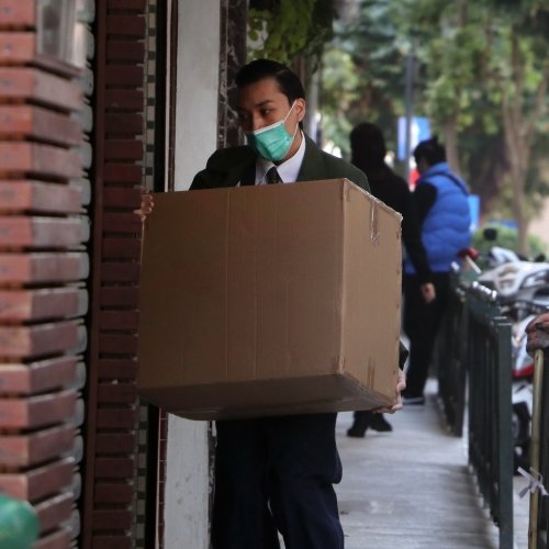 A man in a mask delivering a box