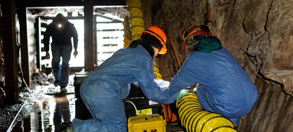 Workers setting up equipment in a mine entrance