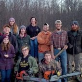 A group of forestry students posing for a photo with chainsaws