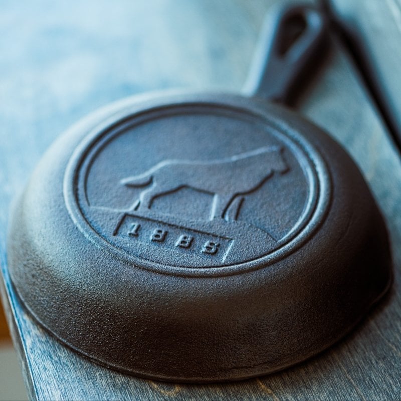 Close up of a cast iron pan with MTU's husky on it.