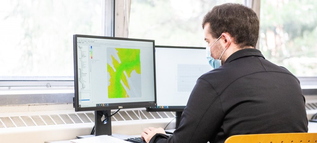 Researcher sitting at computer looking at a geographical map