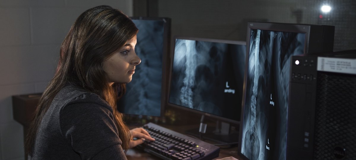 Graduate student viewing x-rays on a computer.