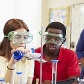 Students wearing goggles working in a lab.