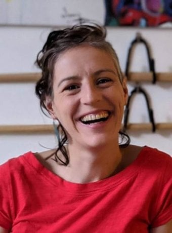Portrait of Estela smiling wearing a red shirt.