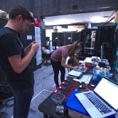Two students prepare microphones for a production in the Rozsa. 