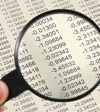Magnifying glass over a page of numbers.