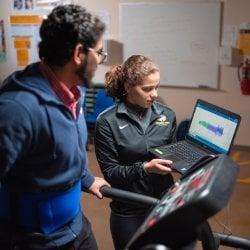 Researcher with laptop, participant on treadmill