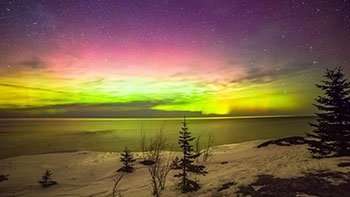 Northern lights over the water in winter.