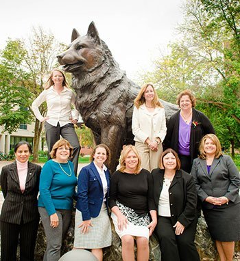 Nine of the twelve new PCA members pose with the husky statue on campus.