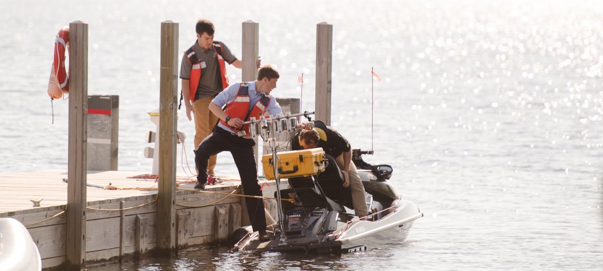 People working on a jet ski at the dock.