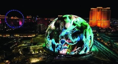 Aerial view of dark Las Vegas with the Sphere in the foreground.