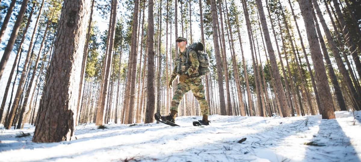 ROTC cadet snowshoeing through the woods.