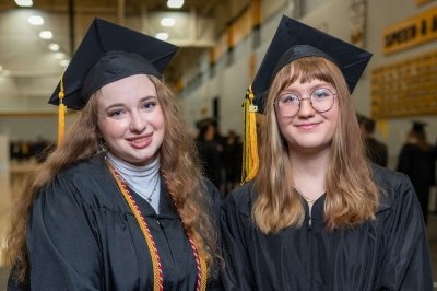 Two graduates wearing caps and gowns.