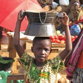 Child carrying a pot on his head.