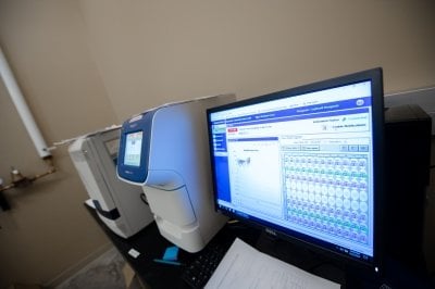 Computer screen and machines for preparing COVID-19 test samples.