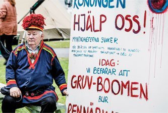 A Sámi man displays a placard appealing to the Swedish king to help in the battle against mining on Sámi land.