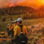 Firefighters in front of a wildfire.