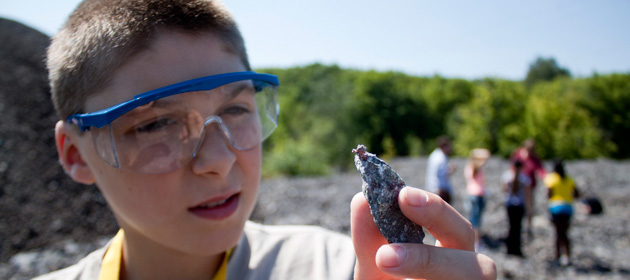 Summer Youth Programs student look at a rock in the Geological Engineering class