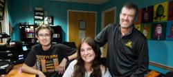 Two Michigan Tech students and their classroom instructor together in the WMTU DJ booth.