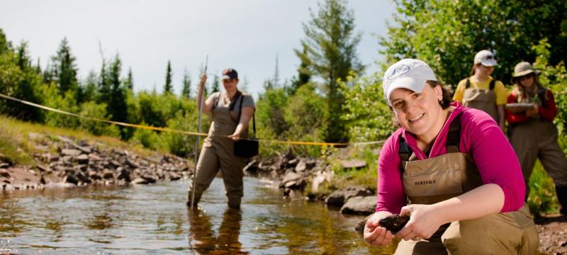 SEveral researchers collecting data from a stream.