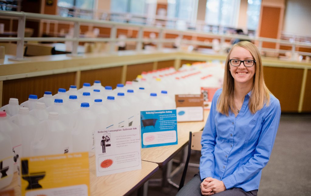 Environmental Engineering major Caryn Murray is seen in front of her World Water Day display in the Memorial Union Building.Using 90 one-gallon jugs, Murray shows how much water is used, and wasted, by individuals each day.