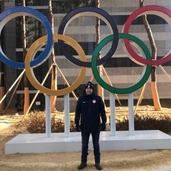 Man standing in front of Olympic rings.