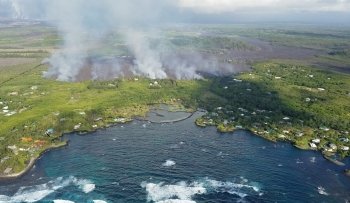 Kapoho Bay in Hawaii with smoke rising from lava.