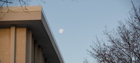 The moon rises over Fisher Hall.