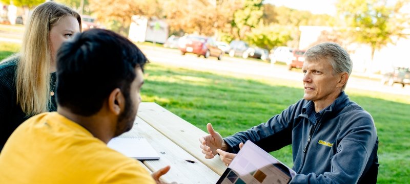 Jon Leinonen talks with college students outside the house the Higher education of Business