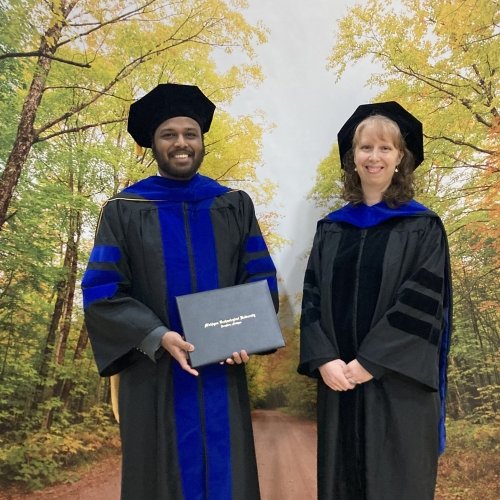 A professor and her graduate student celebrate his Ph.D. award at Michigan Technological University where they also won a research award together.