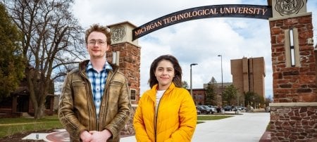 Spring Commencement graduate student speaker Zazil Santizo-Huerta, right, and undergraduate student speaker Vincent Barfield stand under the new Alumni Gateway Arch, which will be dedicated on Friday, April 26, along with a ribbon-cutting for the Universityâ€™s new H-STEM Engineering and Health Technologies Complex.