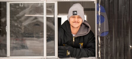 College of Business Husky Hieu Theriault puts his acumen to work on both broomball rinks and balance sheets. He’s shown here in Husky Nation’s iconic Cocoa Shack, where students can warm up with a hot beverage in between broomball games.
