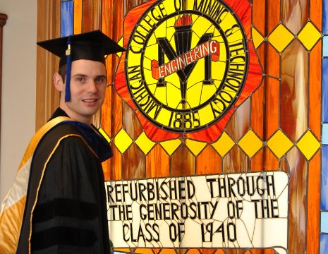 Cameron Hartnell wears Scott Turner's historic academic hood to receive his PhD in industrial heritage and archeology.