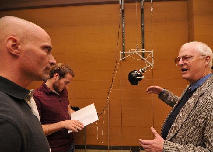 Economics Professor Paul Nelson (right) discusses marketing plans with EBM helmet team.