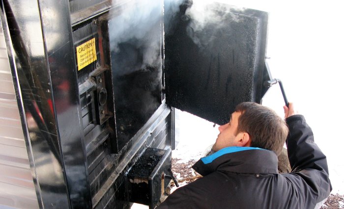 Consumer Product Manufacturing Enterprise team member Ben Stenske checks out the wood boiler.