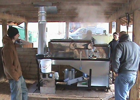 Michigan Tech Forestry and Environmental Resource Management (FERM) members tend the maple syrup evaporator, keeping the fire going, watching tap levels in the pans, making sure it does not  boil over and drawing off the syrup.