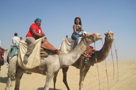 Jasmin Francisco, at right, and Semester at Sea friend Marie Delacruz ride camels through  the Sahara Desert.