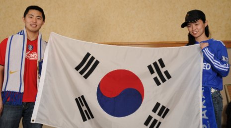 Michael Godfrey and Samantha Leonard hold the taegukgi, the flag of South Korea.