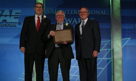 FEV CEO Gary Rogers, left, and 2011 SAE President Richard Kleine, right, present the Franz F. Pischinger Powertrain Innovation Award to John Johnson for lifetime achievement in powertrain research.