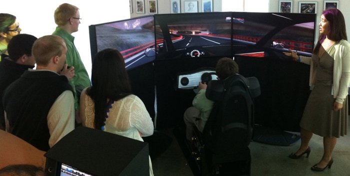 Autodesk employee Grace Hom (right) explains the simulator to the Tech students and driver Andrew Loucks.