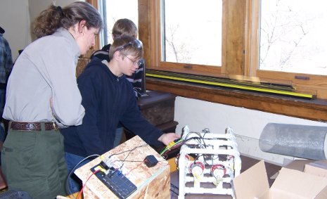 Dollar Bay High School Enterprise student shows an Isle Royale National Park ranger how their remotely operated vehicles work to locate invasive zebra mussels.