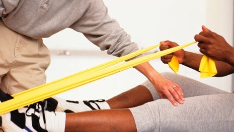 A physical therapist works with a patient.